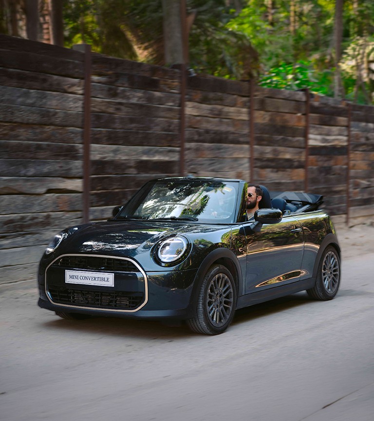 Rear left view of the MINI Cooper Convertible in Sunnyside Yellow parking.